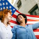 women with american flag behind them
